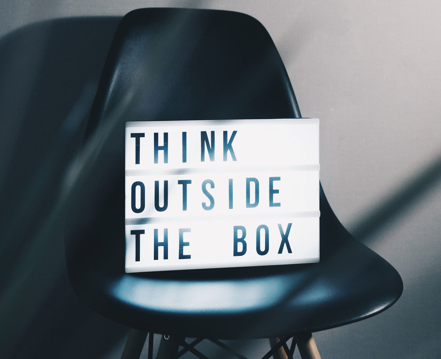 Neon box that reads 'think outside the box'