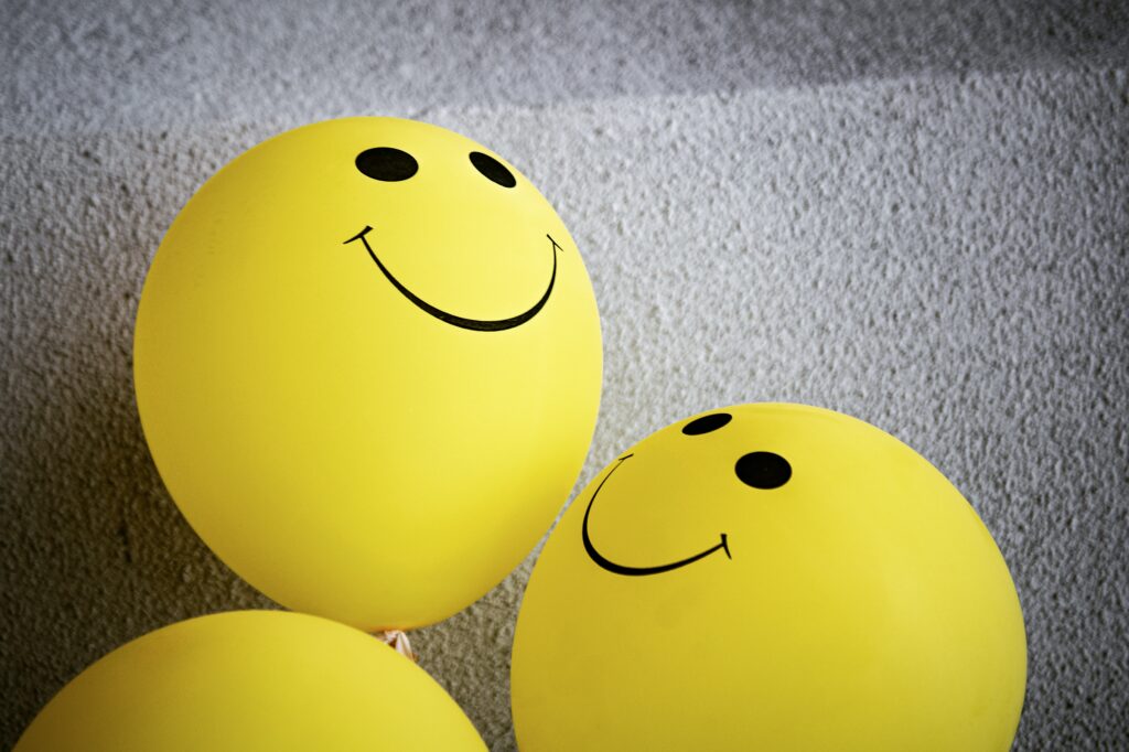 yellow balloons with a smiley face printed on them