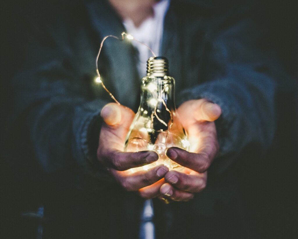 a visual representation of though leadership with a man holding a lightbulb in hands to symbolize his sharing of ideas